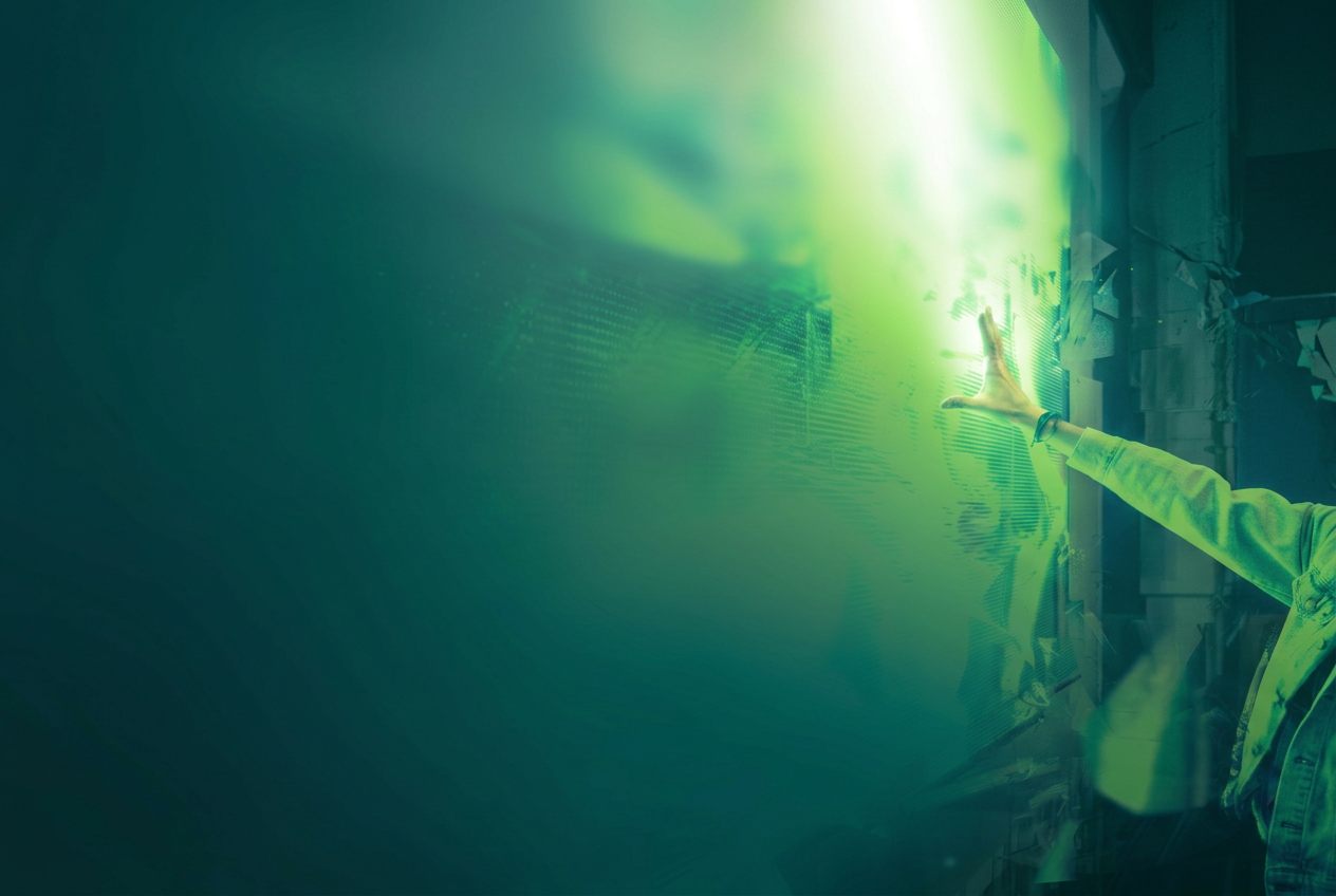 An open hand reaching toward bright green light
